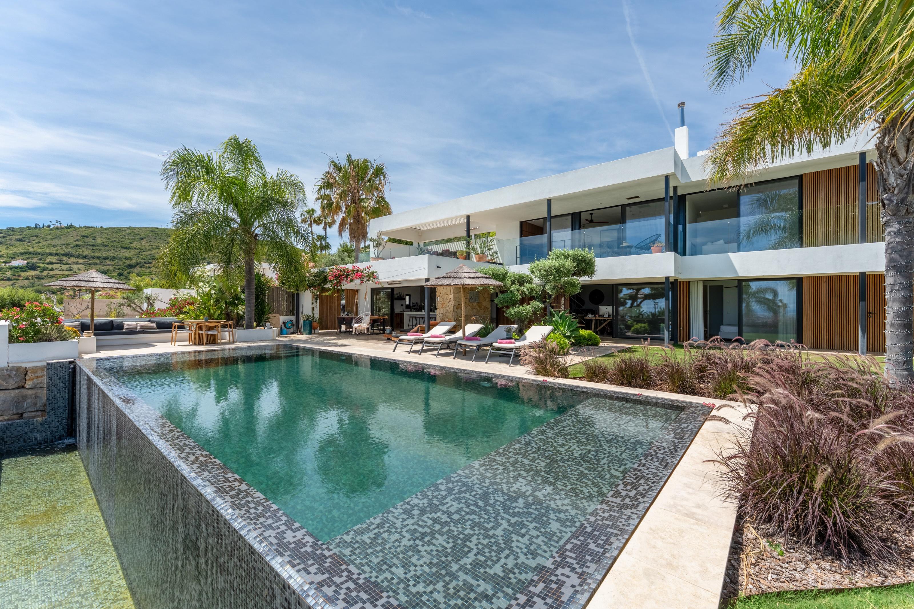 A stunning five-bedroom villa showcasing contemporary architecture ideally located in the heart of Santa Bárbara de Nexe and enjoying breathtaking panoramic sea views.